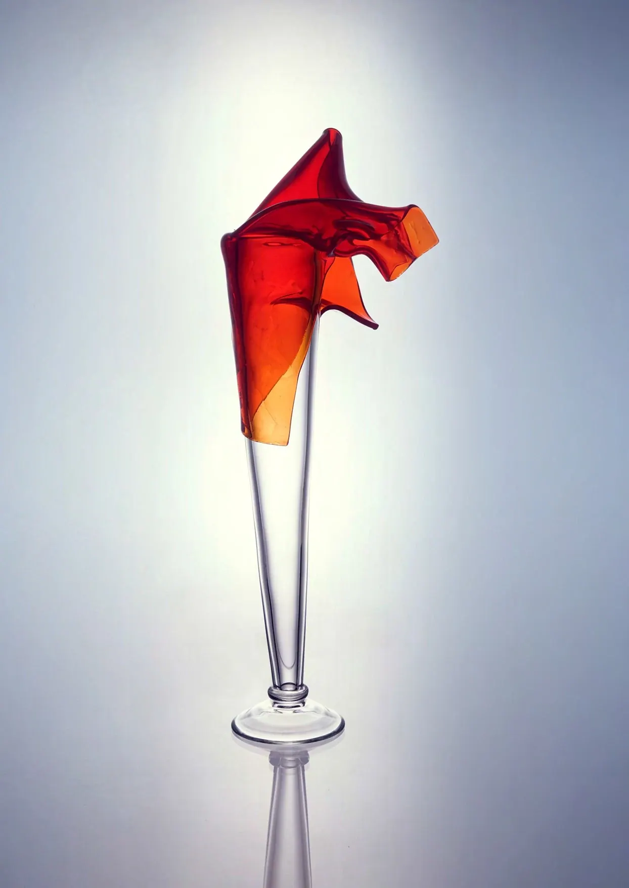 Tall clear crystal stem crowned with a red and orange flame-like top, Crystal art pieces
