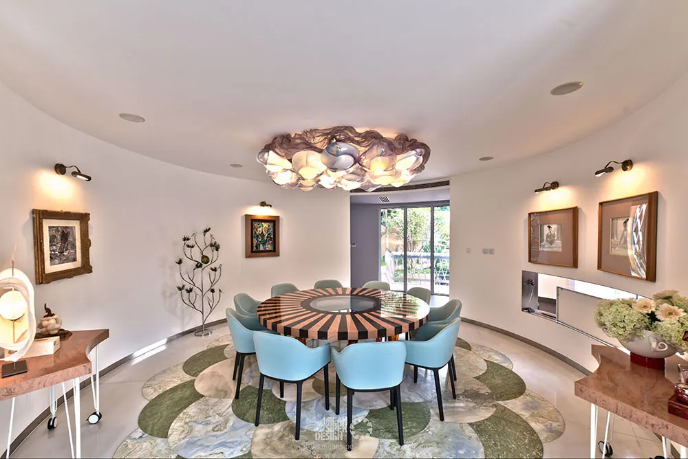 Round dining room with striped round table, pale blue chairs and cloud-like chandelier, Jiujiantang villa