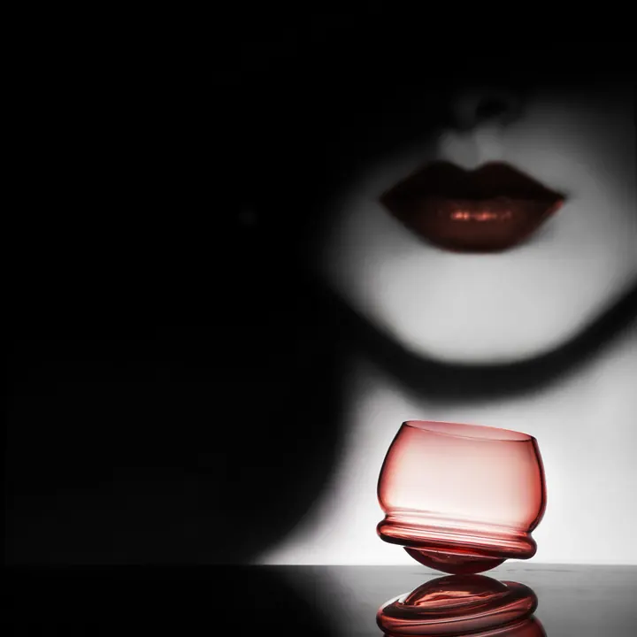 A rocking whiskey glass made from rose coloured crystal