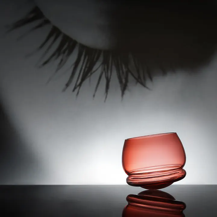 A rocking whiskey glass made from rose coloured crystal